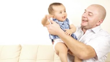 kanepede oturan babası ile gülen bebek