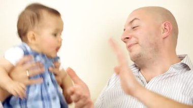 bebeğin anne ve babayla kanepede oturan gülümsüyor.