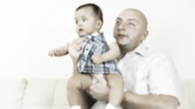 kanepede oturan babası ile gülen bebek
