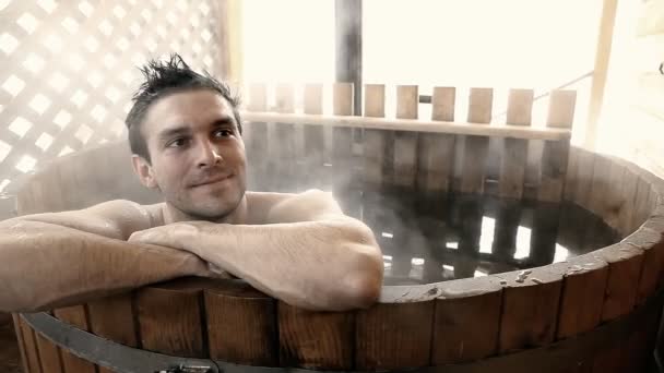 Man sitting in hot water outdoor at winter — Stock Video