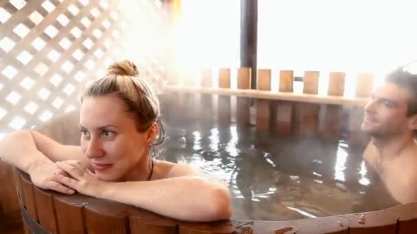 Paar sitzt im Winter im warmen Wasser — Stockvideo