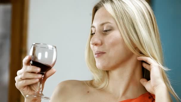Schöne blonde Frau trinkt Rotwein in der Bar — Stockvideo