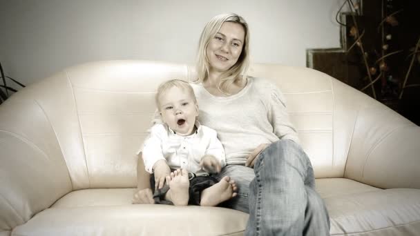 Мама с сыном на диване смотрят телевизор — стоковое видео