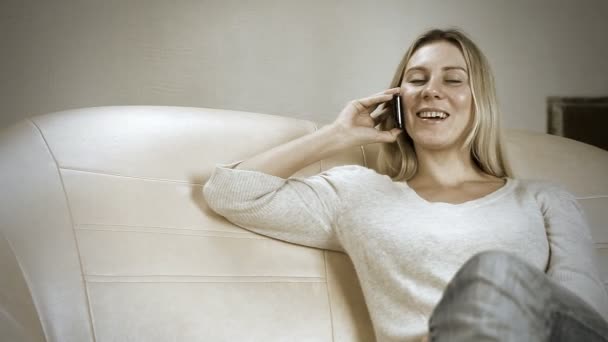 Menina bonita no sofá falando por telefone — Vídeo de Stock