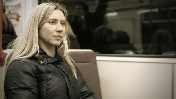 Schöne junge Frau sitzt in U-Bahn — Stockvideo