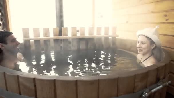 Ζευγάρι συνεδρίαση σε ζεστό νερό είναι εξωτερική στο χειμώνα — Αρχείο Βίντεο