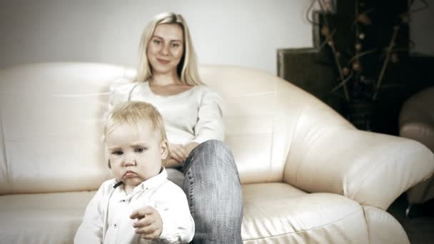 Madre con hijo en sofá ver televisión — Vídeo de stock
