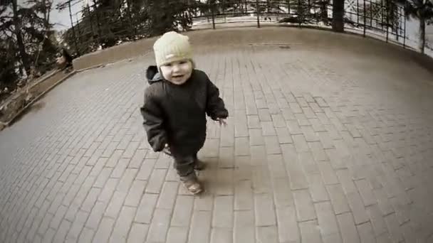 Дитина грає в парку, біжить за камерою — стокове відео