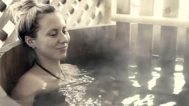 坐在热水在冬季室外的女性 — 图库视频影像