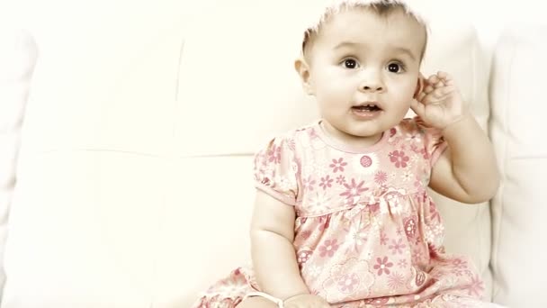 Χαμογελώντας μωρό κάθεται στον καναπέ — Αρχείο Βίντεο