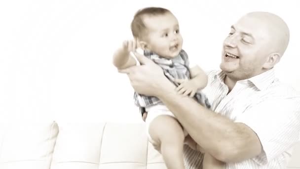 Glimlachende baby met vader zittend op de Bank — Stockvideo