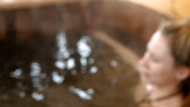 Femme assise dans l'eau chaude en plein air en hiver 