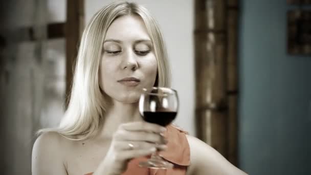 Όμορφη ξανθιά γυναίκα που πίνει κόκκινο κρασί στο μπαρ — Αρχείο Βίντεο
