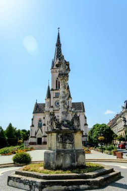 Güneşli bir günde Koszeg 'deki Kutsal Yürek Kilisesi' nin önündeki Veba Kolonu Kutsal Üçlü Heykeli..