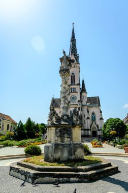 Güneşli bir günde Koszeg 'deki Kutsal Yürek Kilisesi' nin önündeki Veba Kolonu Kutsal Üçlü Heykeli..
