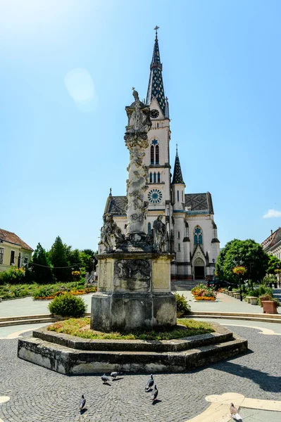 Güneşli bir günde Koszeg 'deki Kutsal Yürek Kilisesi' nin önündeki Veba Kolonu Kutsal Üçlü Heykeli..
