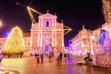 LJUBLJANA, SLOVENIA - 15 HAZİRAN 2022: Preseren Anıtı ve Fransisken Kilisesi 'ne gece vakti insanlar Preseren Meydanı' nda yürürken bakın