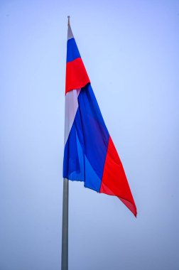 Mavi gökyüzüne karşı Slovenya bayrağı. İzole edilmiş.