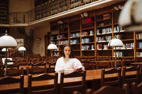 Жінка Білій Сорочці Читає Книгу Атмосферній Бібліотеці Міста Столом Серйозним — стокове фото