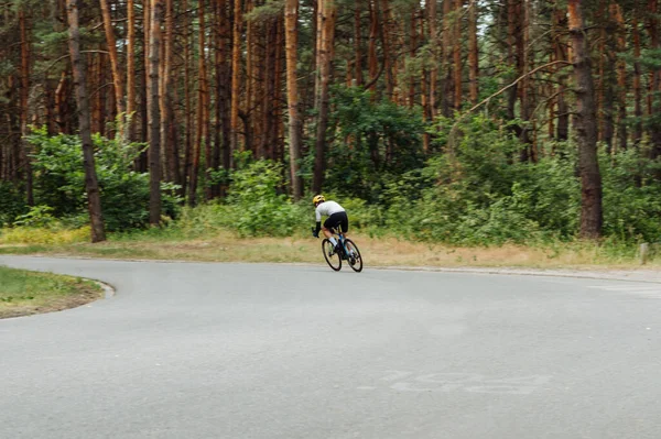 Foto Eines Radsportlers Bewegung Beim Training Auf Einer Asphaltierten Waldstraße — Stockfoto