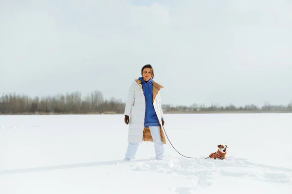 Γυναίκα Χειμωνιάτικα Ρούχα Στέκεται Στο Χιόνι Ένα Σκυλί Λουρί Και — Φωτογραφία Αρχείου