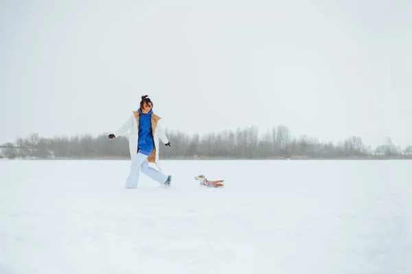 Χαρούμενη Γυναίκα Ιδιοκτήτης Τρέχει Ένα Μικρό Σκυλί Ένα Χιονισμένο Πεδίο — Φωτογραφία Αρχείου