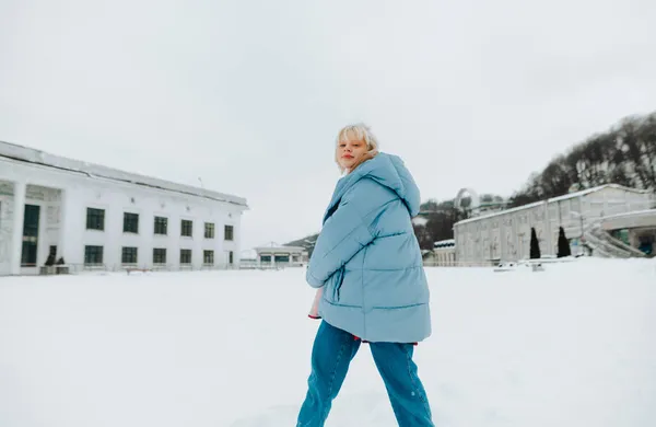 Vacker Flicka Vinterkläder Snurrar Snöig Gata Och Ler Mot Kameran — Stockfoto