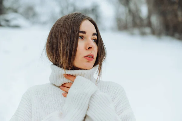 눈덮인 거리에서 스웨터를 얼굴로 카메라를 아름다운 여인의 — 스톡 사진