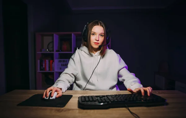 カメラを見て深刻な顔を持つコンピュータ上の自宅でビデオゲームをプレイする美しい女性ゲーマー 女性ストリーマーオンラインゲーム — ストック写真