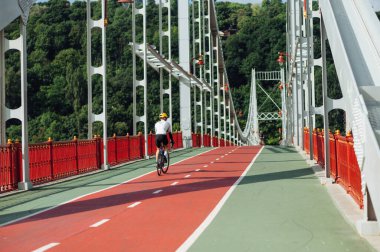 Spor malzemesi giymiş bisikletçiler köprüde bisiklet sürüyor..