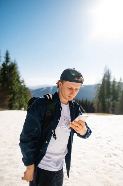 산에서 눈덮인 산비탈에 로이서 관광객 이심각 얼굴을 스마트폰을 사용하고 — 스톡 사진