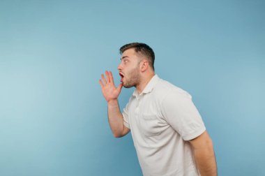 Sakallı bir adam avucunun içinde mavi bir arka planda izole bir şekilde bağırıyor..