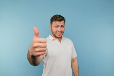 Mavi arka planda tüyleri olan, yüzünde bir gülümseme olan olumlu, komik bir adam..