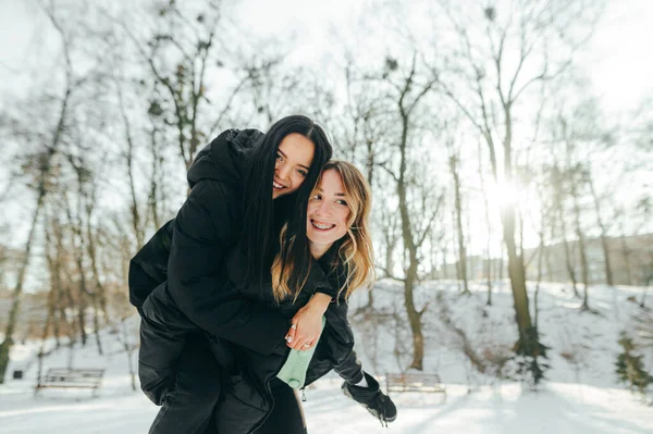 Δύο Χαρούμενα Κορίτσια Που Διασκεδάζουν Μια Βόλτα Στο Χειμερινό Πάρκο — Φωτογραφία Αρχείου