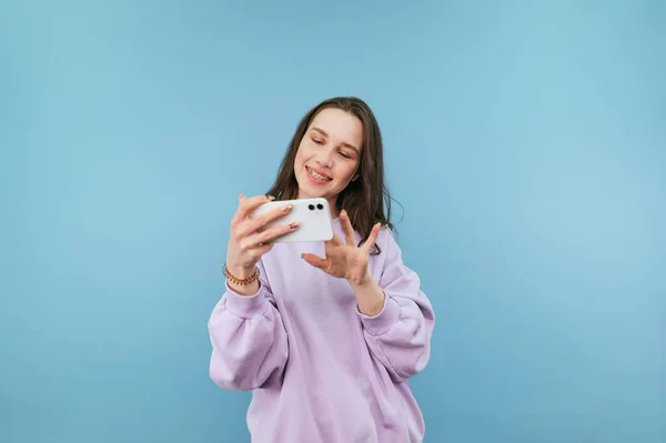 Menina Atraente Uma Camisola Roxa Fica Com Smartphone Suas Mãos — Fotografia de Stock