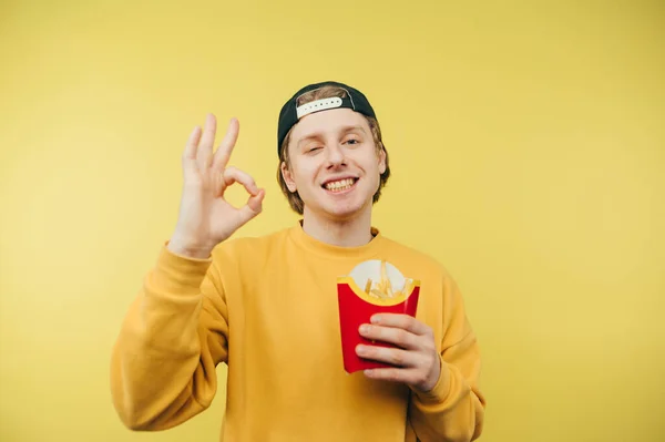 Positivo Giovane Uomo Abiti Casual Tiene Mano Patatine Fritte Mostra — Foto Stock