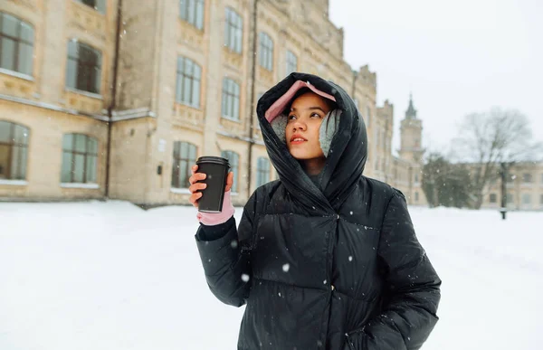 Atrakcyjna Kobieta Spaceruje Zimowych Ulicach Miasta Filiżanką Kawy Nich Patrzy — Zdjęcie stockowe