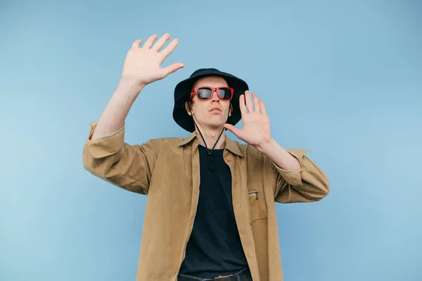 Αστείος Νεαρός Άνδρας Γυαλιά Ηλίου Χορεύει Μπλε Φόντο Χέρια Σηκωμένα — Φωτογραφία Αρχείου