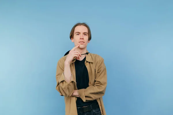 Jovem Bonito Uma Camisa Fica Fundo Azul Olha Para Câmera — Fotografia de Stock