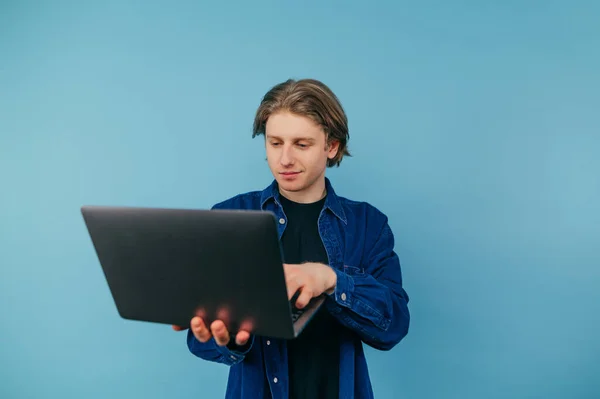 Joven Positivo Con Portátil Sus Manos Levanta Sobre Fondo Azul —  Fotos de Stock