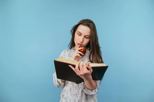 Seriös Dam Klänning Läser Intresserad Bok Med Äpple Handen Blå — Stockfoto