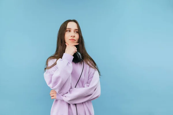 Pensive Liggend Sweatshirt Hoofdtelefoon Staand Een Blauwe Achtergrond Wegkijkend Met — Stockfoto