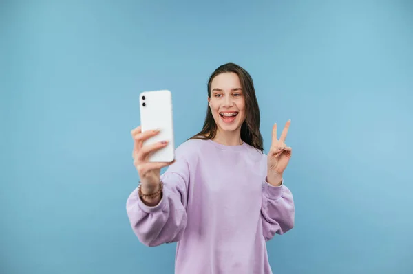 Senhora Positiva Camisola Roxa Fica Fundo Azul Tira Uma Selfie — Fotografia de Stock