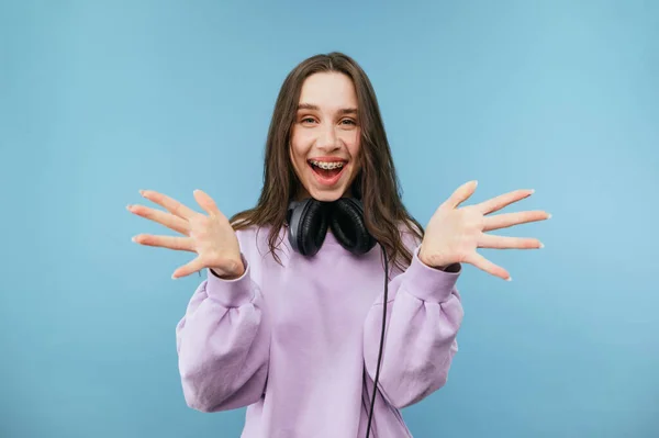 Πορτρέτο Ενός Χαρούμενου Κοριτσιού Μοβ Ρούχα Και Ακουστικά Μπλε Φόντο — Φωτογραφία Αρχείου