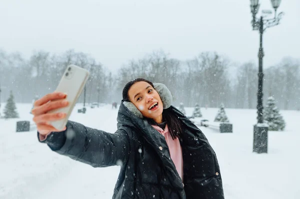 Посміхаючись Своїй Жінці Теплому Одязі Вона Приймає Селфі Смартфон Снігопаді — стокове фото