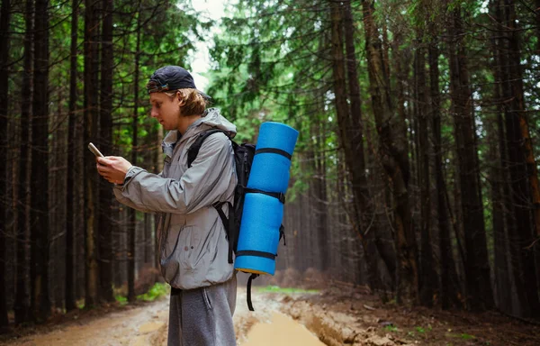 Чоловік Турист Рюкзаком Стоїть Гірській Дорозі Калюжами Використовує Смартфон Тлі — стокове фото