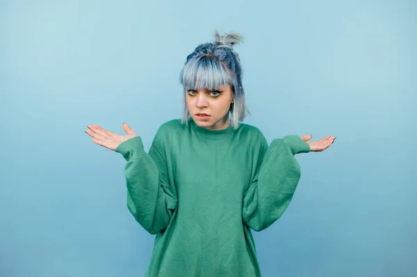 Retrato Una Adolescente Desconcertada Suéter Verde Sobre Fondo Azul Mirando —  Fotos de Stock