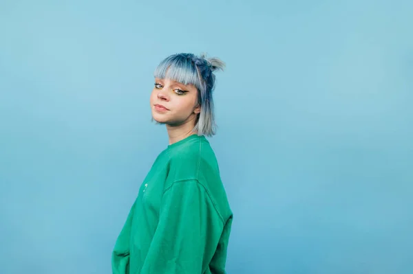 Menina Hipster Bonita Uma Camisola Verde Fica Fundo Azul Posa — Fotografia de Stock