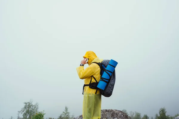 하이킹을 관광객 비옷을 배낭을 산꼭대기에 전화로 의사소통을 — 스톡 사진