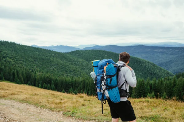 산속을 배경으로 비현실적 풍경을 배경으로 가방을 여행자 돌아보는 — 스톡 사진